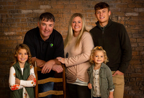 A family standing outside in the fall.